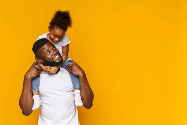 Schattig Afrikaans meisje zittend op Daddys schouders — Stockfoto