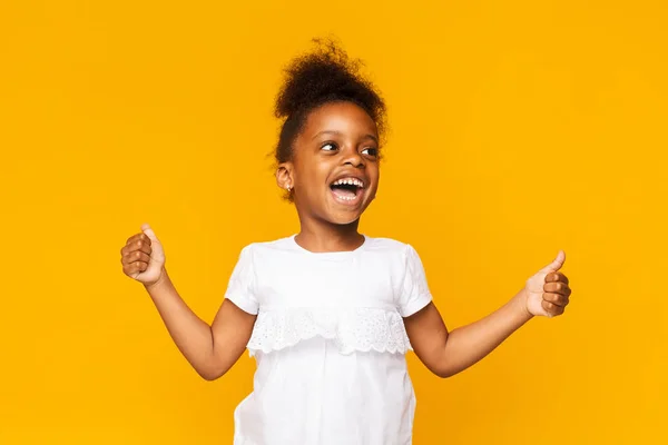 Emocional niña africana mostrando los pulgares hacia arriba y gritando — Foto de Stock
