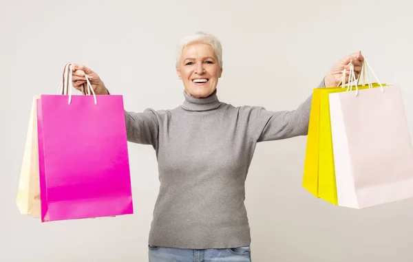 カラフルなショッピングバッグでポーズをとる幸せな高齢女性 — ストック写真