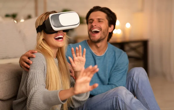 Casal feliz usando fone de ouvido VR se divertindo em casa — Fotografia de Stock