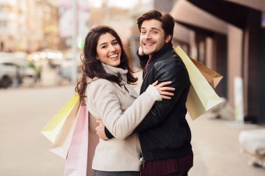 Alışveriş çantaları ile loving çift açık havada kucaklayan