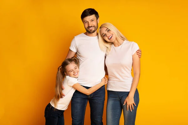 Liefdevolle ouders en dochter omarmen staande in Studio — Stockfoto