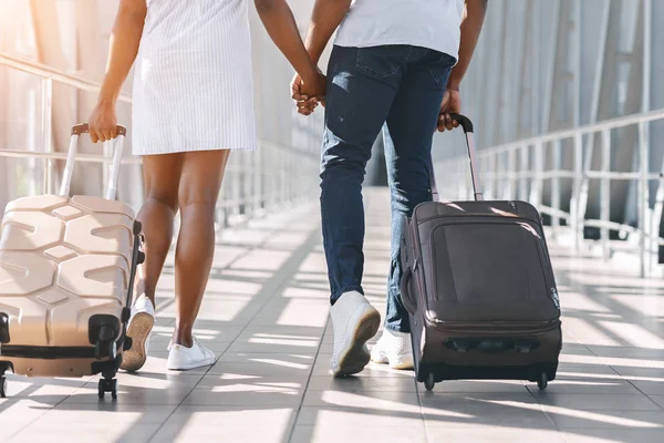 Negro millennial pareja caminando con equipaje en el aeropuerto —  Fotos de Stock