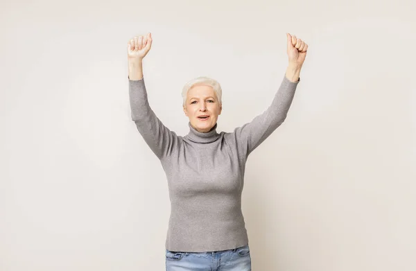 Пожилая женщина с поднятыми кулаками в воздухе — стоковое фото