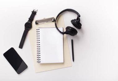 Beyaz arka planda cep telefonu, dizüstü bilgisayar ve kulaklıklar