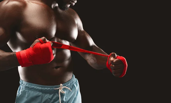 Afrikanischer amerikanischer Kämpfer wickelt rote Binde um seine Hand — Stockfoto