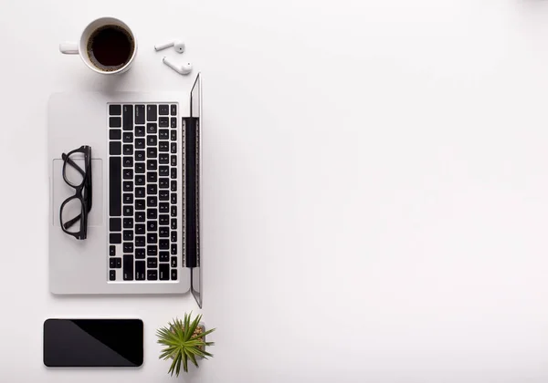 Top view of stylish workspace with laptop, coffee and cellphone