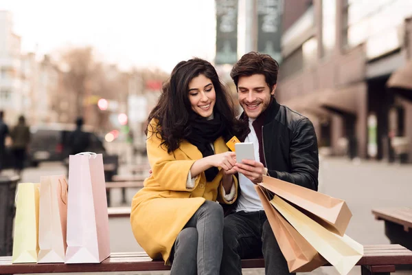 Giovane coppia seduta sulla panchina dopo lo shopping — Foto Stock