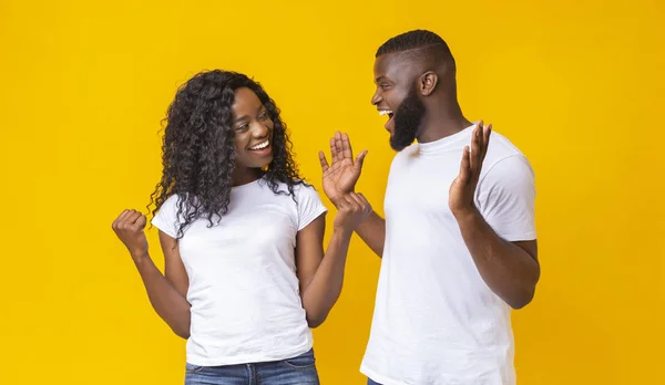 Negro hombre y mujer felizmente sorprendido con buenas noticias — Foto de Stock