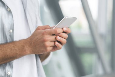 Havaalanında cep telefonuyla gezinen adam, yakından