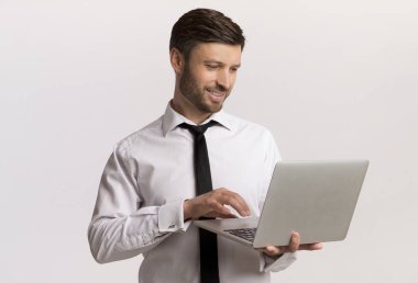 Beyaz arka plan üzerinde dizüstü bilgisayarda çalışan iş adamı