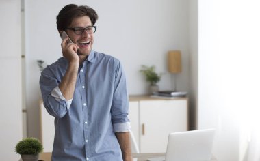 Girişimci ofiste ayakta cep telefonu ile konuşan