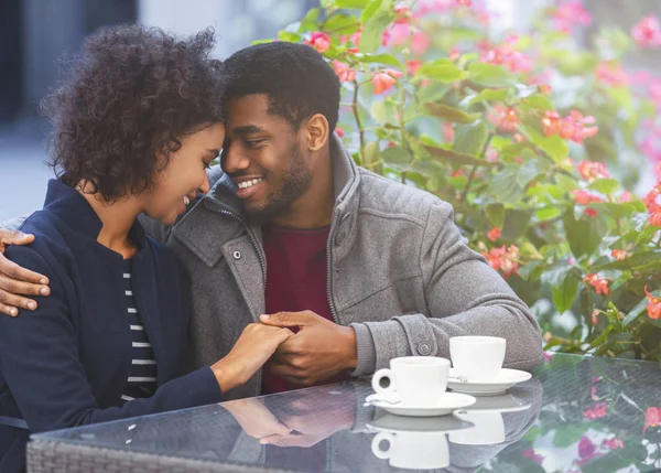 Dulce pareja africana tomándose de las manos en la cafetería —  Fotos de Stock