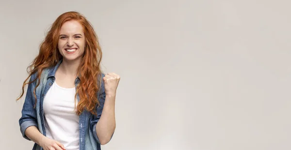 Emocional chica sonriendo y levantando el puño apretado en el aire — Foto de Stock