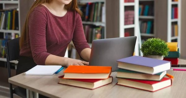 年轻的女学生使用笔记本电脑和书籍做作业 — 图库照片