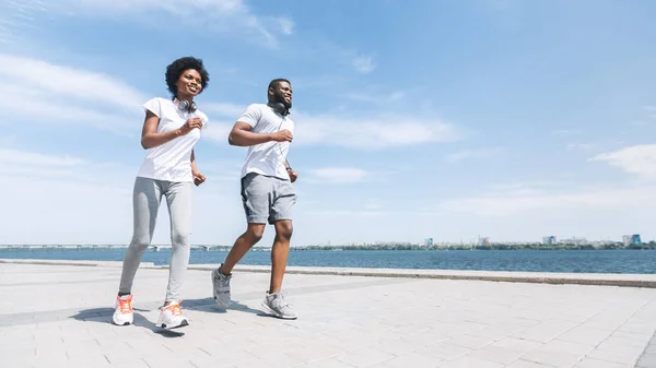 Sposi afroamericani che fanno jogging vicino alla riva del fiume, Panorama — Foto Stock