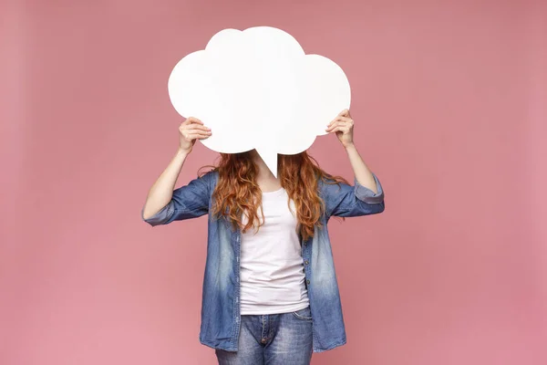 Ruiva fêmea escondendo seu rosto atrás de branco bolha discurso branco — Fotografia de Stock