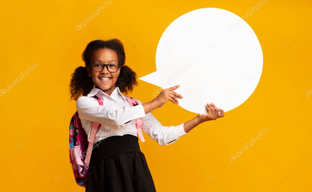 Black Schoolgirl Holding Speech Bubble In Studio