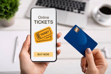 Online bilet uygulaması ve kredi kartı ile akıllı telefon tutan kadın