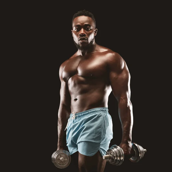 Retrato de esportista afro-americano segurando halteres — Fotografia de Stock