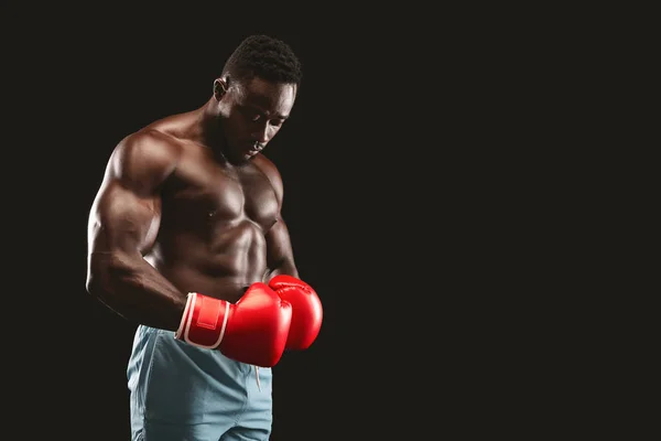 Luchador africano con guantes rojos posando sobre fondo negro —  Fotos de Stock