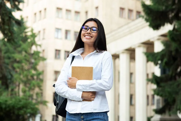 兴奋的学生女孩拿着书，微笑着对着镜头 — 图库照片