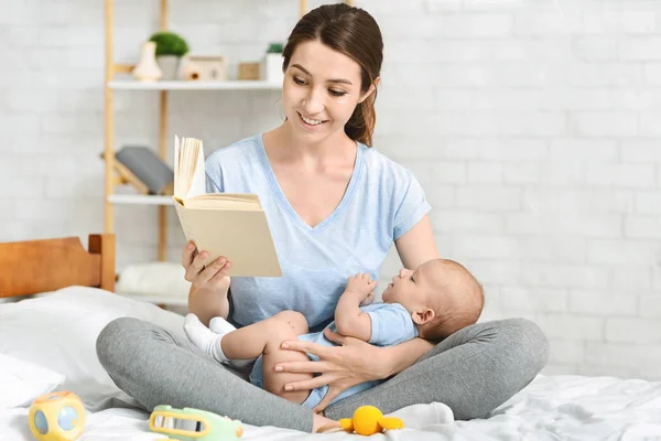 Молода мати читає книгу своїй новонародженій дитині — стокове фото