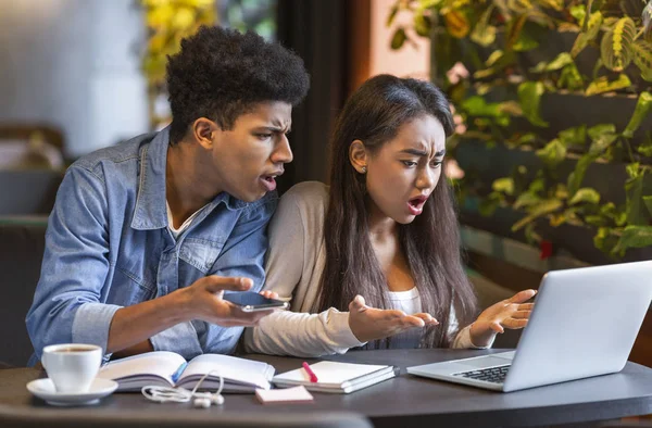 Desperate students looking at laptop with furious faces