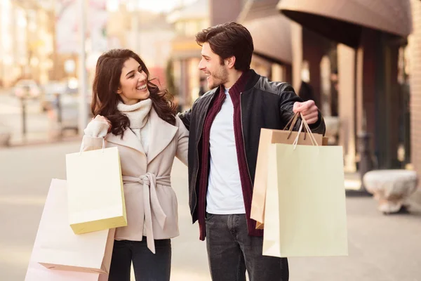 Casal feliz andando com sacos de compras no dia de outono — Fotografia de Stock