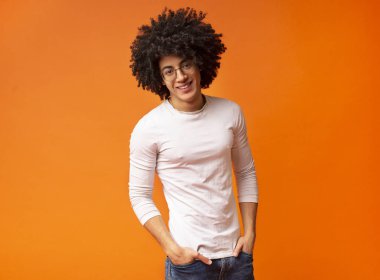 Kendine güvenen siyah adam ceplerinde elleri ile gülüyor