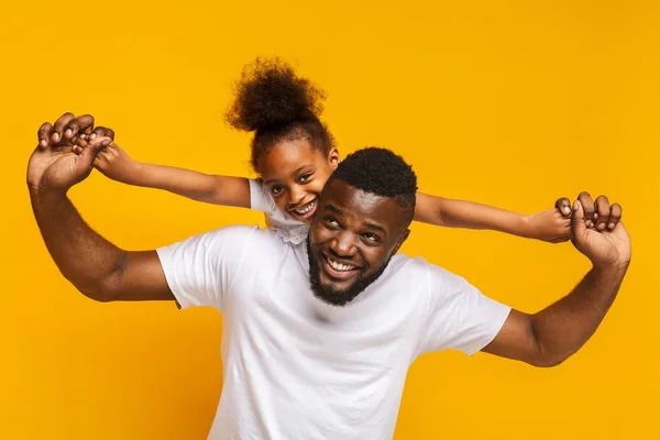 Veselá malá Africká Američanka jede na tatínkova zpátky — Stock fotografie
