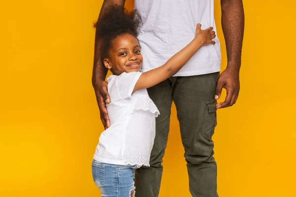 Щаслива маленька афро-дівчинка обіймає свого тата дуже важко — стокове фото