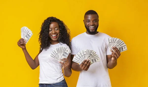 Alegre negro pareja celebración dinero y sonriendo —  Fotos de Stock
