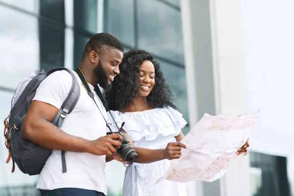 Heureux touristes africains à la recherche de carte, itinéraire près de l'aéroport — Photo