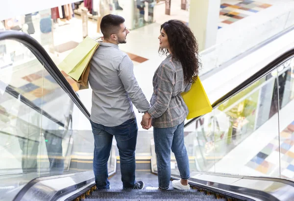 Concept de consumérisme. Jeune couple descendant par escalator — Photo