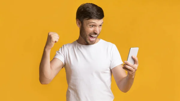 Happy Man Holding Cellphone Shaking Fists Celebrating Success, Panorama — Stok Foto