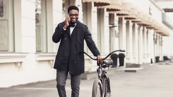 Trygg affärsman gå med cykel och pratar på mobiltelefon — Stockfoto