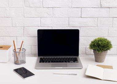 Ofis masasında siyah ekranlı dizüstü bilgisayar