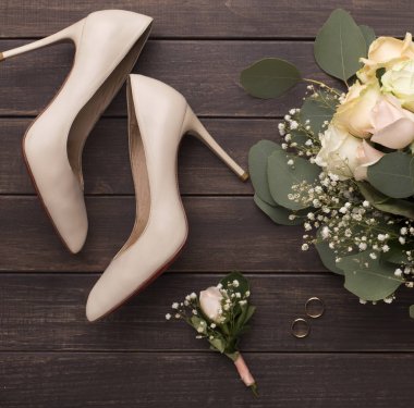Gelin damat yaratıcı düz kadın ayakkabı ve gül buket yatıyordu