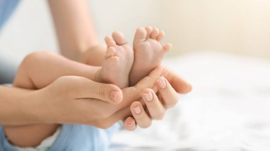 Bakım anne elinde yeni doğmuş bir bebeğin Minik ayakları