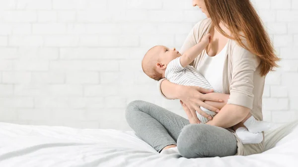 Jovem mãe embalando bebê recém-nascido em seus braços — Fotografia de Stock