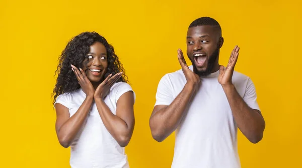 Casal afro-americano chocado olhando um para o outro — Fotografia de Stock