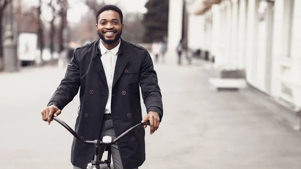 Bonito empresário de casaco andando de bicicleta na rua da cidade — Fotografia de Stock