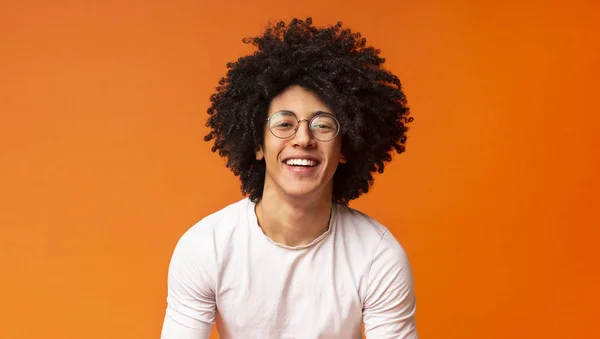 Feliz millennial preto cara rindo no fundo laranja — Fotografia de Stock