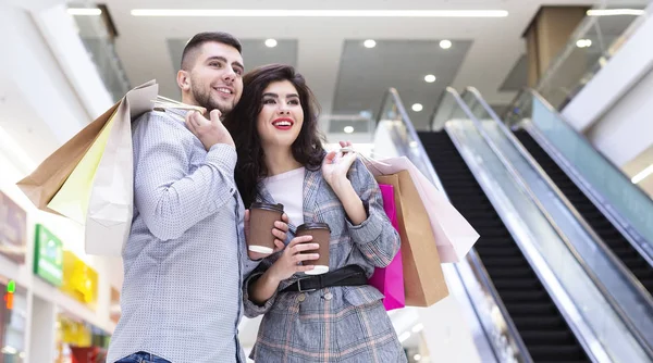 Joyeux couple marchant au centre commercial, buvant du café — Photo