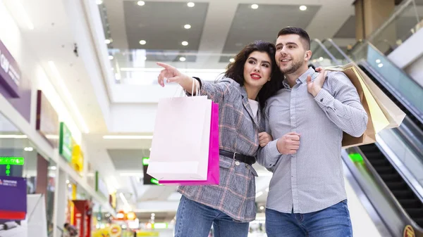 Concepto de ventas. Mujer mostrando hombre tienda en el centro comercial —  Fotos de Stock