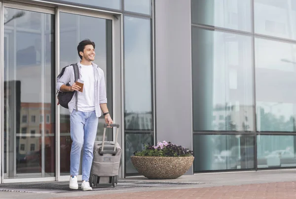 Lycklig kille går ut från flygplatsen byggnad med bagage — Stockfoto