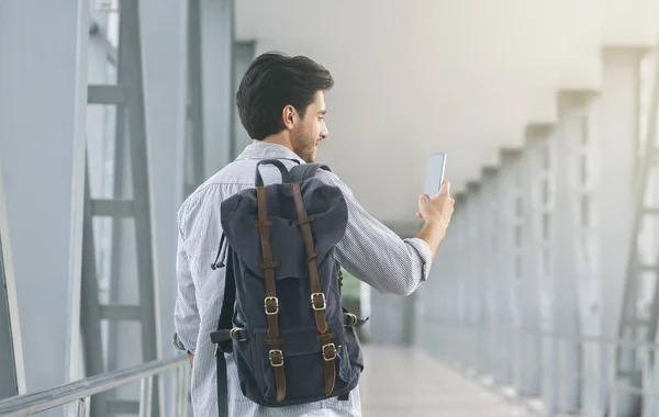Turista usando su celular en el aeropuerto, conectándose a roaming — Foto de Stock