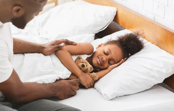 Afrikalı baba uyuyan küçük kızını koruyor — Stok fotoğraf