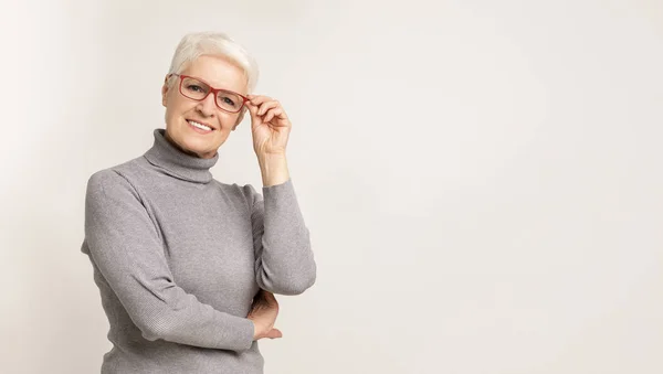 Beautiful aged businesswoman in elegant glasses smiling at camera — Stock Photo, Image